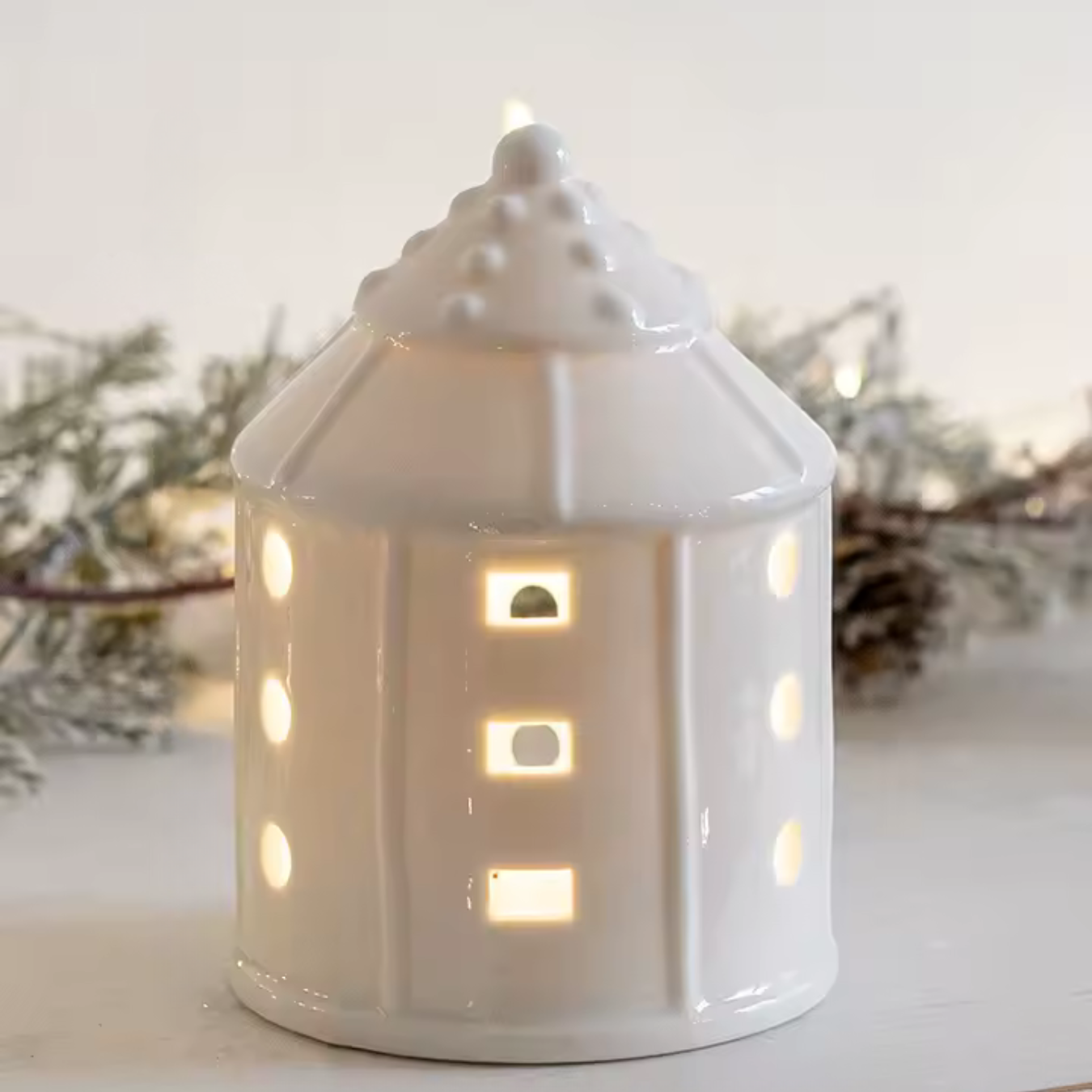 Weißes Keramikhaus mit LED-Licht für festliche Atmosphäre