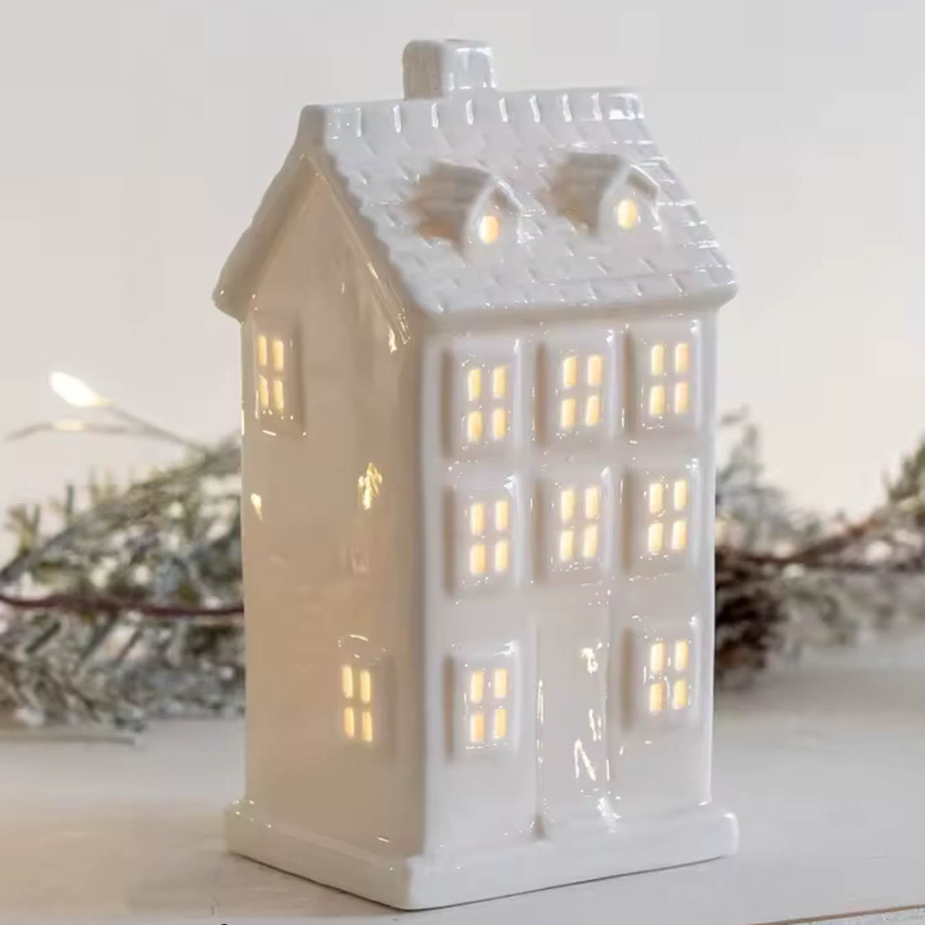 Weißes Keramikhaus mit LED-Licht für festliche Atmosphäre