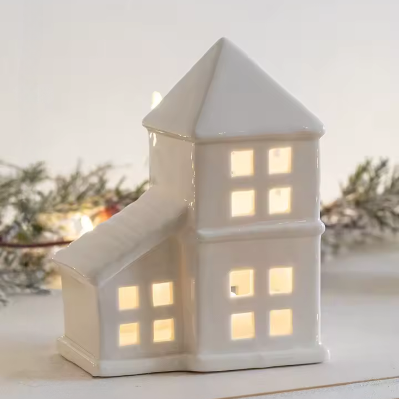 Weißes Keramikhaus mit LED-Licht für festliche Atmosphäre