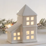 Weißes Keramikhaus mit LED-Licht für festliche Atmosphäre